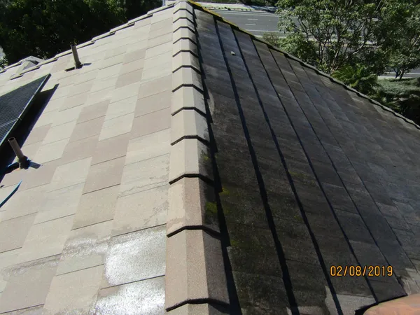 Technician cleaning a tile roof